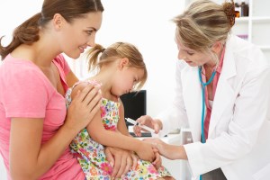 woman holding child with a doctor