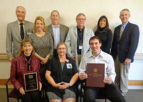 group of people holding awards